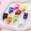 A collection of colorful acrylic letter beads in various shades including pink, blue, yellow, orange, green, purple, and blac