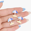 A hand holds several enamel marine life charms shaped like umbrellas in shades of blue and pink.