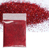 A small plastic bag filled with vibrant red holographic glitter powder scattered on a white surface.