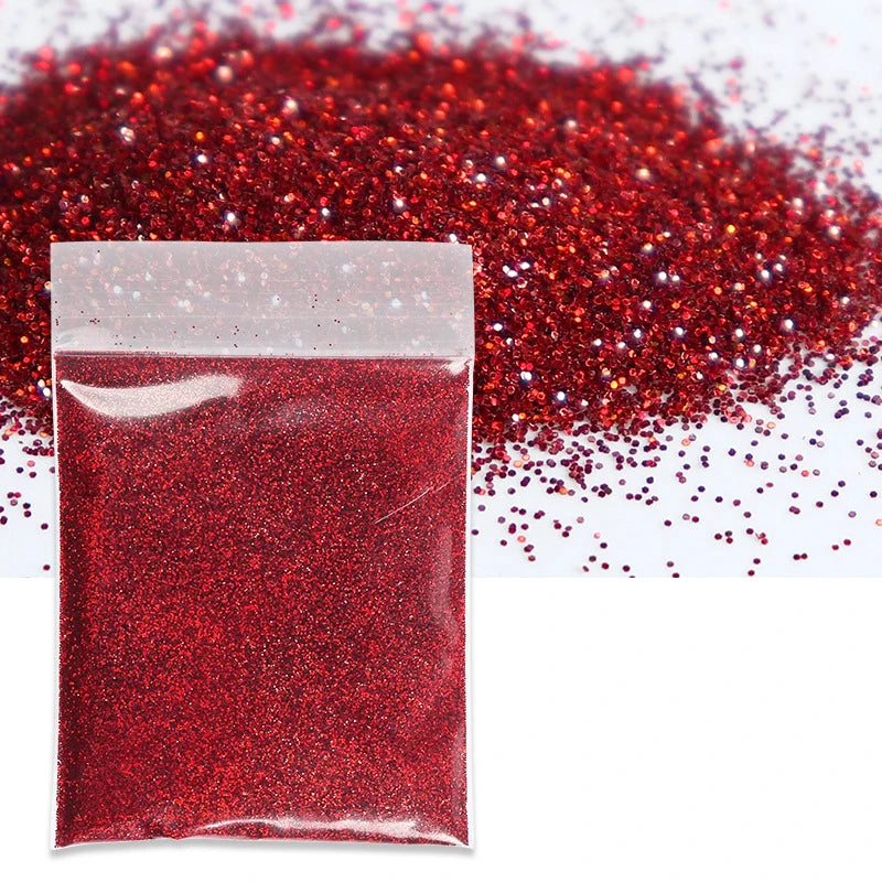 A small plastic bag filled with vibrant red holographic glitter powder scattered on a white surface.