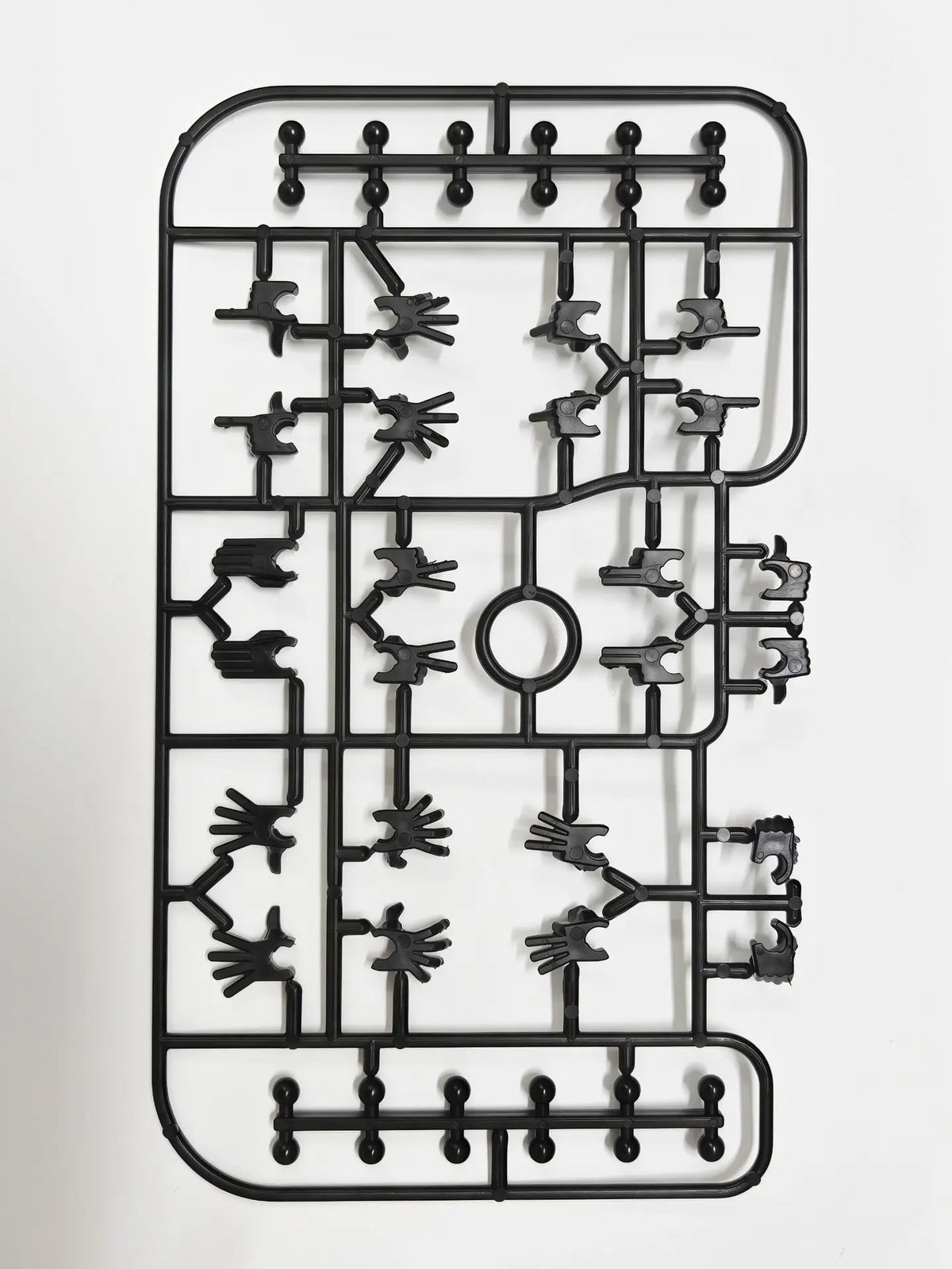 A black magnetic multi-jointed action figure building set with a display stand.
