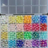 A grid of mixed color resin beads for jewelry making in various shades of yellow, green, blue, pink, and purple.