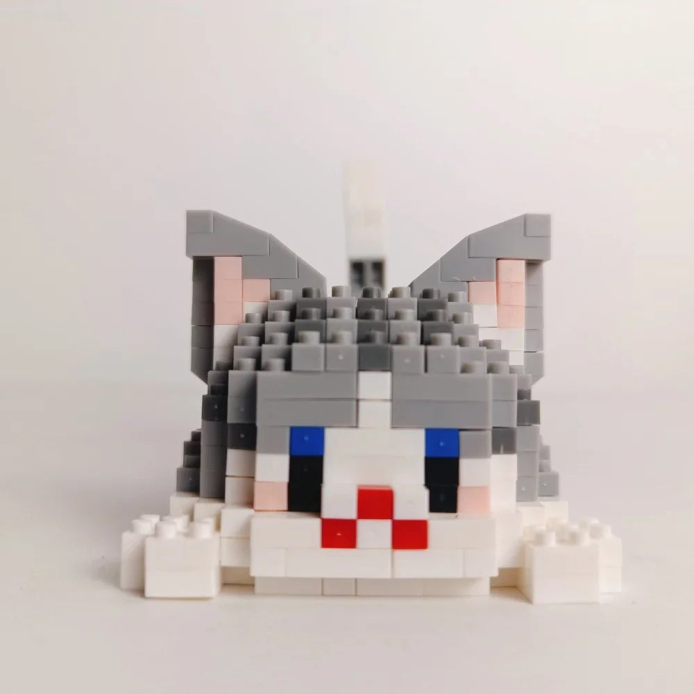 A miniature cat face built from gray and white LEGO bricks.