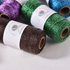 Rolls of metallic glitter yarn in purple, green, and blue for knitting and crochet projects