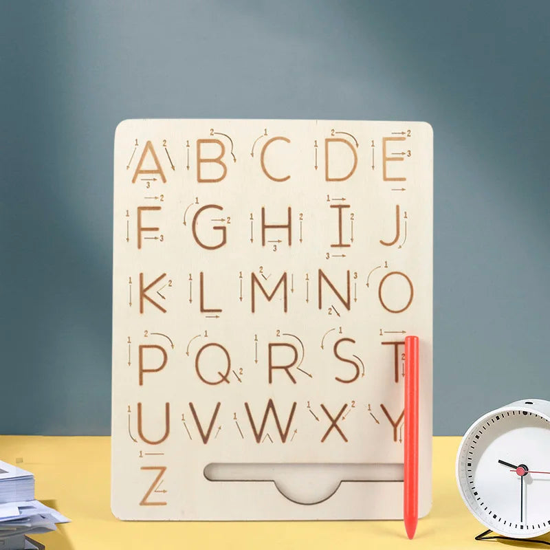 A wooden Montessori letter tracing board showing the alphabet from A to Z carved into the wood.