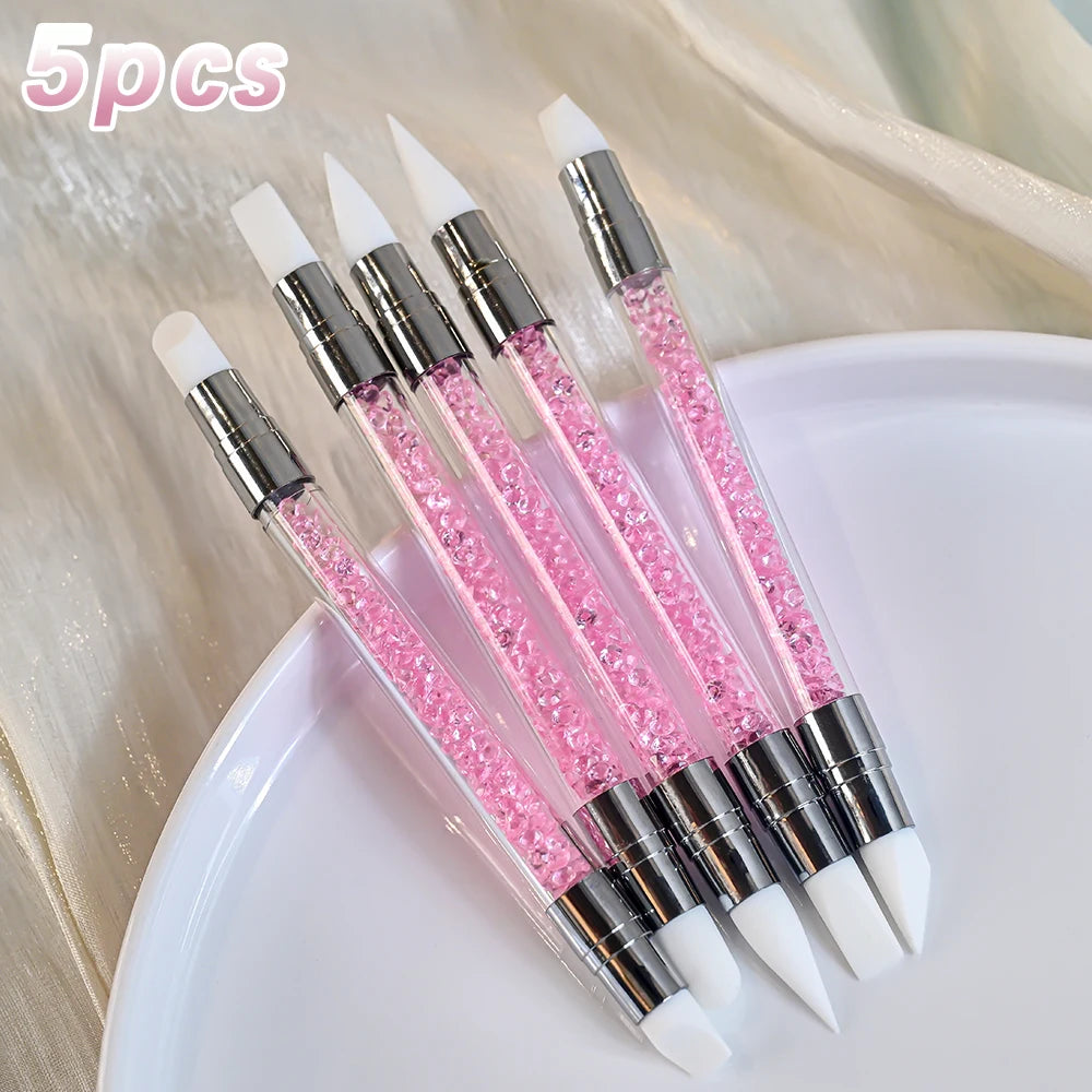 A set of five double-ended silicone dotting pens with pink and white tips displayed on a white plate.