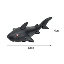 A black plastic toy shark building block with dimensions 13cm long and 4cm high.