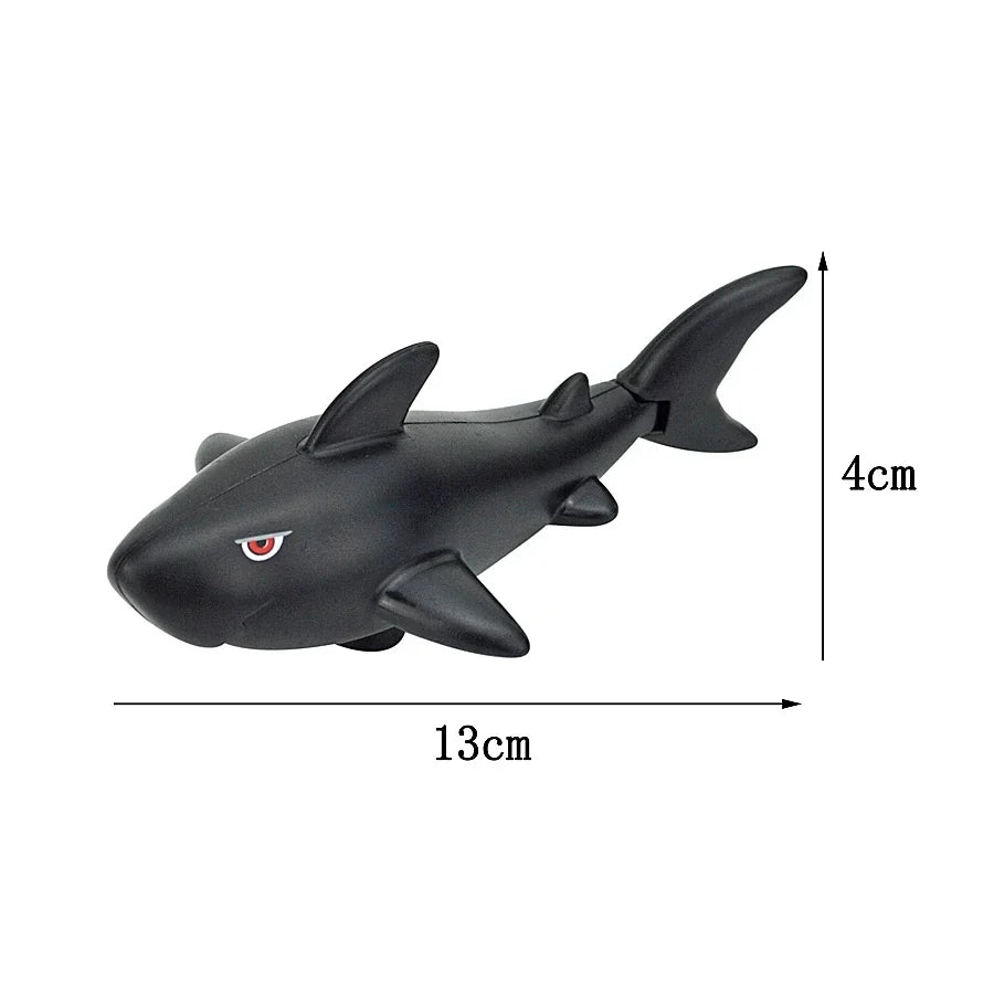 A black plastic toy shark building block with dimensions 13cm long and 4cm high.