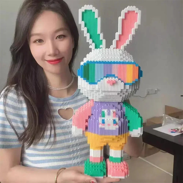 Une femme tient un set de blocs de construction colorés en forme de lapin et d'ours, faits de micro-briques.