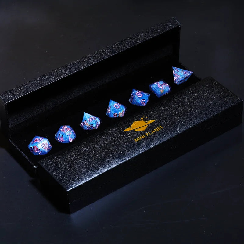 A set of six iridescent blue polyhedral dice displayed inside a black box.