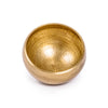 A golden handcrafted Tibetan singing bowl with a hammered texture, shown against a white background.