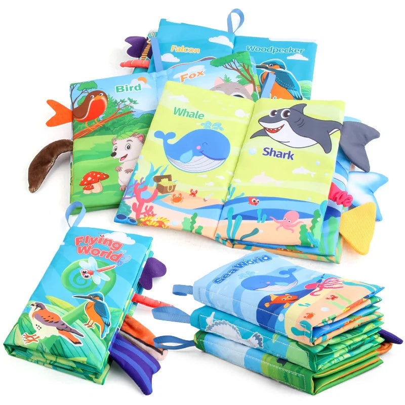 A collection of soft fabric baby books featuring animals like birds, whales, and sharks with tails and sound pages.