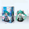 PVC figure of Hatsune Miku with teal hair and black outfit displayed in its box.