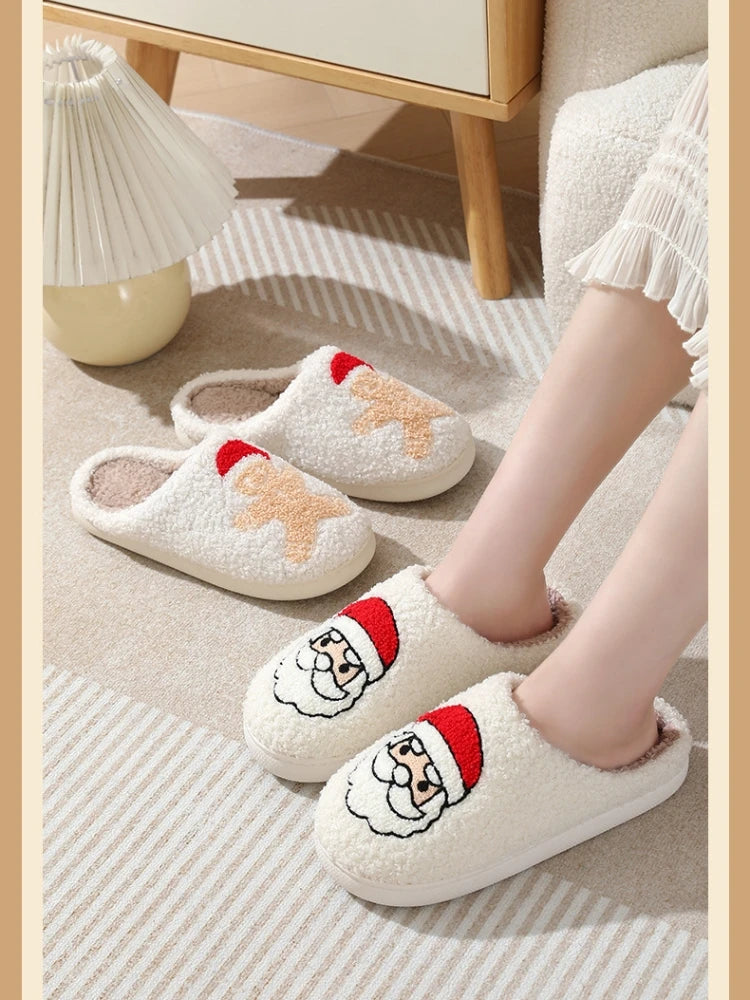 A close-up of a pair of white plush non-slip indoor slippers with red and orange accents resting on a light beige rug.