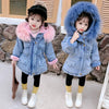 Two children wearing blue denim jackets with faux fur collars and black leggings and white boots.