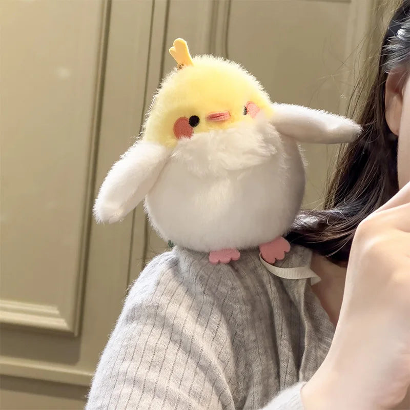A yellow and white cartoon bird plush toy with a beak is shown against a light background.