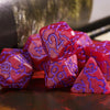 A set of seven frosted red resin polyhedral dice resting on a dark surface.