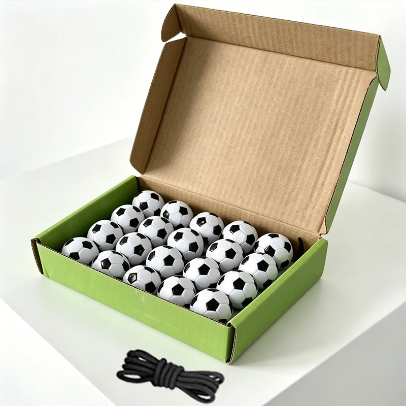A cardboard box filled with black and white magnetic soccer balls is displayed on a white surface.
