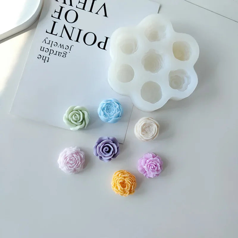 A white silicone mold set with multiple flower shapes in various pastel colors is displayed on a white surface.