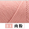 Close-up of pink milk cotton yarn showing a knitted texture and twisted strands.