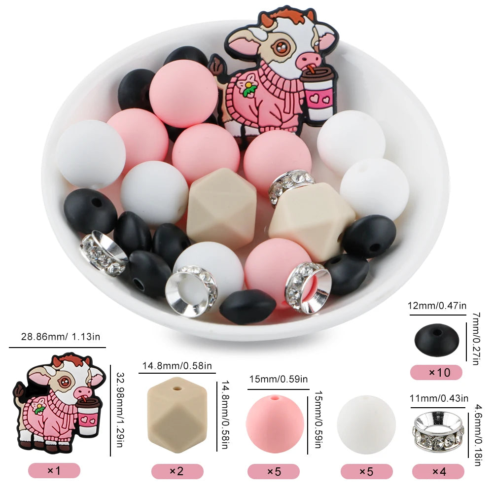 A variety of pink, white, and black cartoon animal silicone beads for DIY jewelry making are displayed in a white bowl.