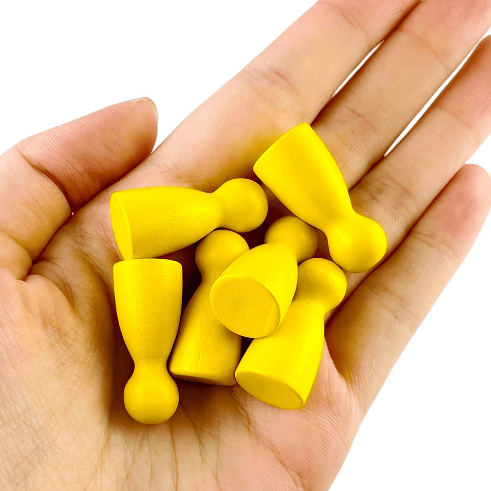 A hand holds a set of twelve wooden game pawns in various shades of yellow.
