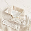 A close-up of a cream fleece-lined winter coat with a textured collar and half-zip closure.