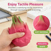 A hand holds a pink fruit-shaped squishy stress relief toy with realistic texture and shape on a wooden surface.