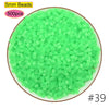 A pile of 5mm green beads, 500 pieces, used for craft projects or pixel art.