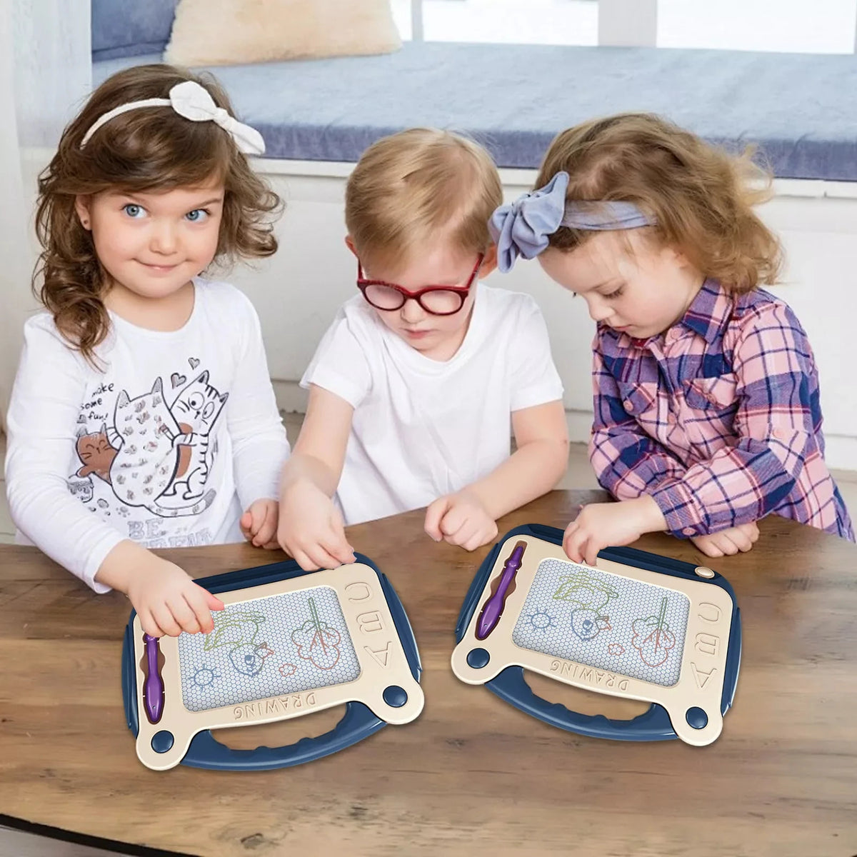Three children are using a blue magnetic drawing board for creative learning and sketching.