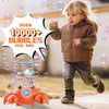 Un jeune enfant joue avec une machine à bulles de crabes orange automatique à l'extérieur.