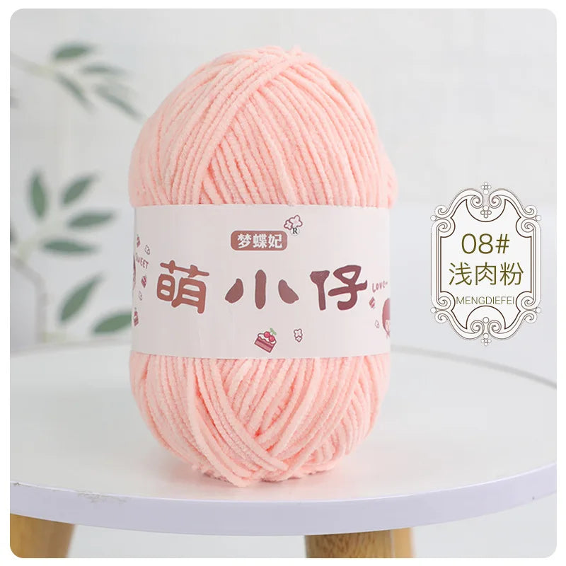 A ball of soft pink chenille yarn labeled for knitting and crochet with Chinese characters.