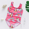 Pink one-piece swimsuit featuring a unicorn design with rainbow accents and clouds