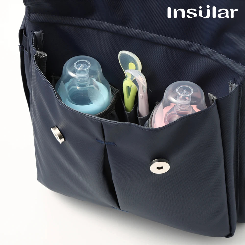 A dark blue waterproof diaper backpack is shown open, displaying various bottles and accessories.