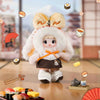 A fluffy white plush keychain of a character dressed in traditional Japanese attire, surrounded by various food items.