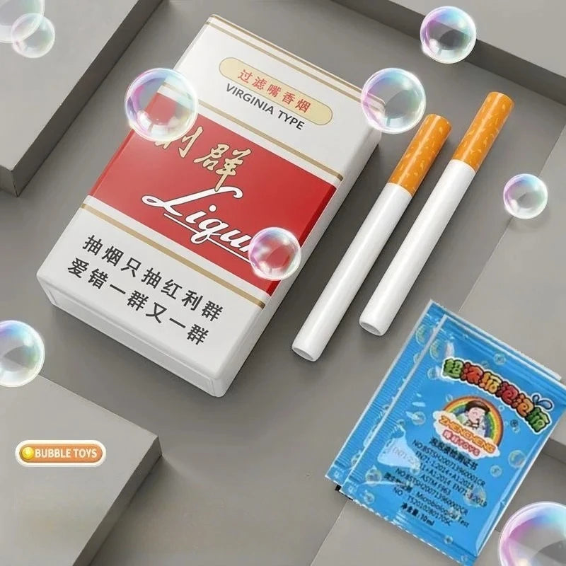 A box of novelty cigarette bubble blowers is shown next to several white and orange blowers on a gray surface.