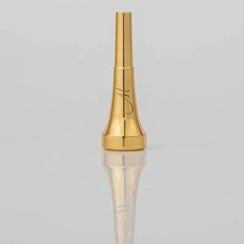 A gold-plated trumpet mouthpiece with a tapered design and an engraved signature.