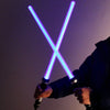 A person holds a glowing blue lightsaber with a cross shape against a dark background.