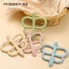 A collection of soft silicone butterfly teethers in green, pink, and blue are displayed next to a woven basket.
