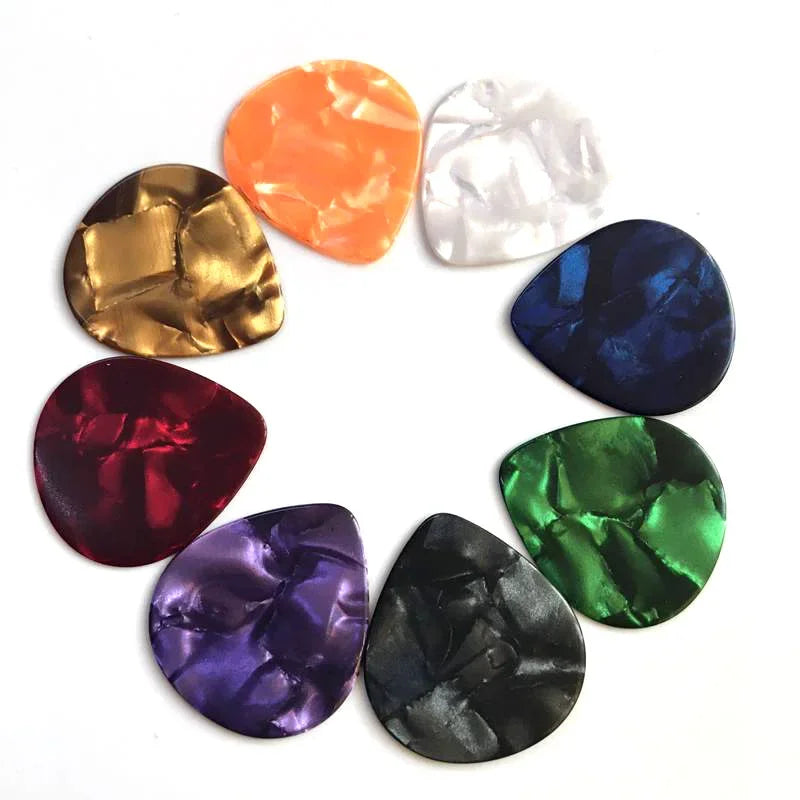 A collection of ten guitar picks made from celluloid in various colors including orange, gold, silver, and various shades of 