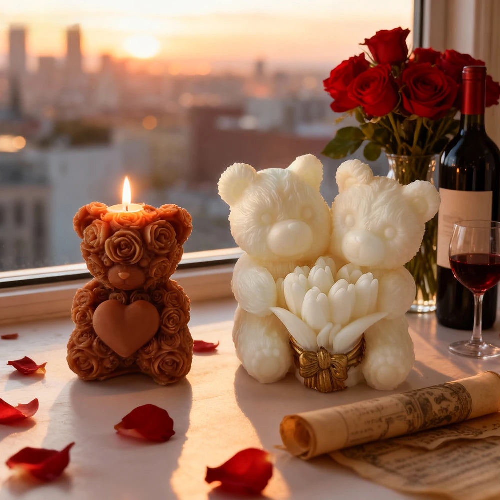 A white silicone bear candle mold sits next to a red rose bouquet and a glass of red wine by a window at sunset.