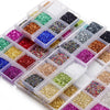 A collection of colorful crushed glass stones in various shades and sizes organized in clear plastic compartments.