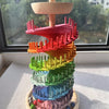 A colorful sensory music tree with a marble run structure made of stacked, brightly colored wooden pieces.