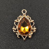 Gold plated water droplet charm featuring a faceted amber crystal rhinestone set in an ornate flower design.