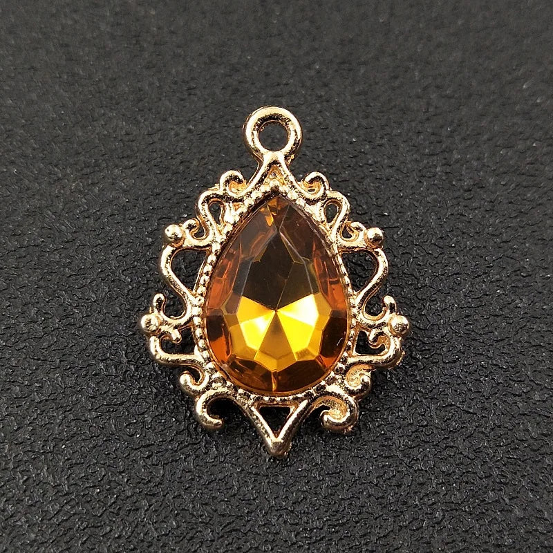 Gold plated water droplet charm featuring a faceted amber crystal rhinestone set in an ornate flower design.