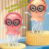 A pink jellyfish toy with large glasses and glowing lights standing on a yellow base.