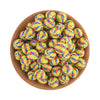 A bowl filled with colorful, yellow and green patterned silicone beads for jewelry making.