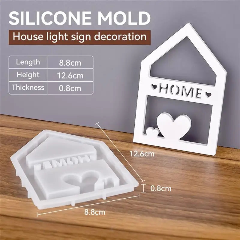 A white silicone mold set for creating house, heart, and Christmas ornaments on a wooden surface.