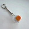 Silver chain keychain with an orange and white translucent keycap fidget item