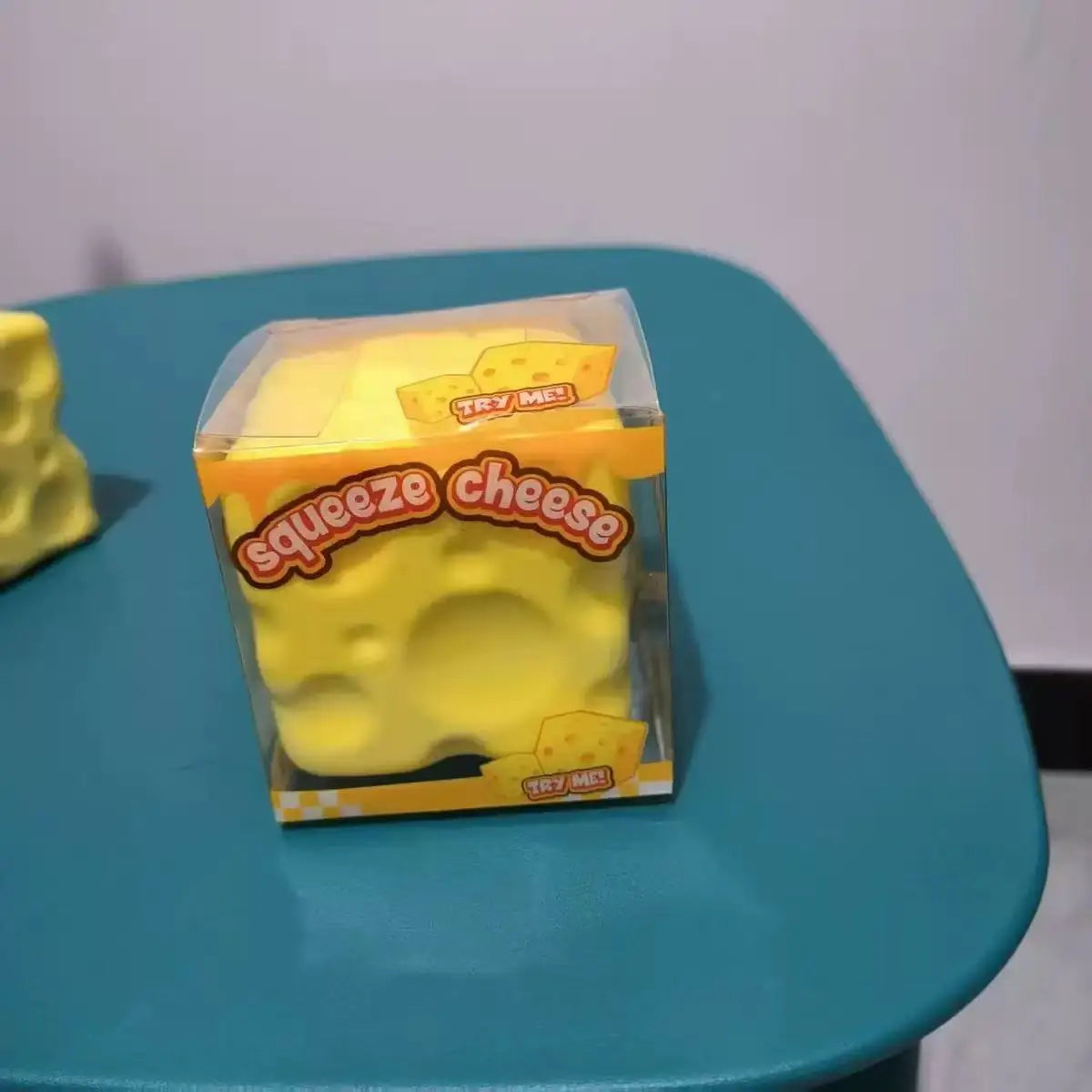 Eine Packung von streßlinderndem, gelbem Queetschäfer auf einer blauen Oberfläche.